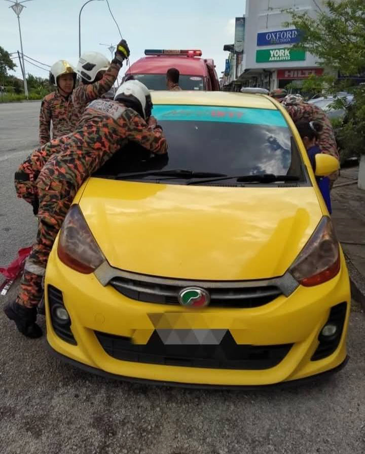 消防员设法打开车门，以救出受困孩童。（霹消拯局）