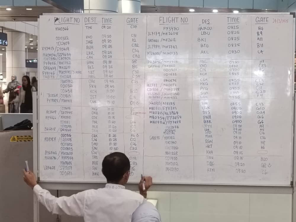 机场职员将航班讯息写在白板上。