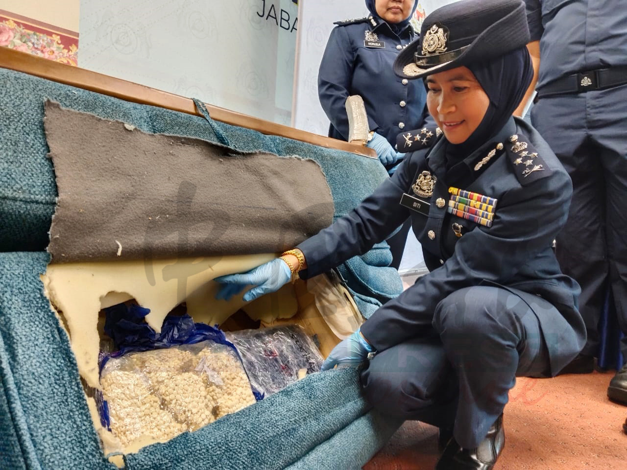 关税局副总监西蒂检查被藏在沙发内的毒品。