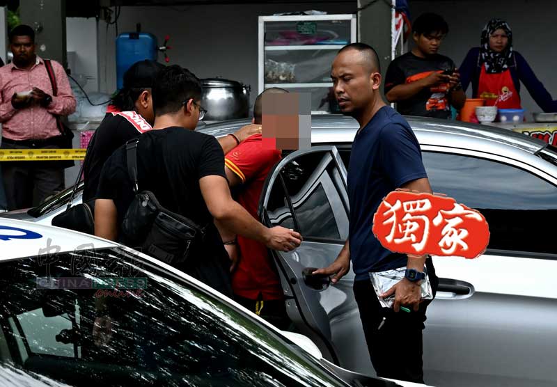 身穿红衣的嫌凶，被警方押上警车前往警局作深入调查。
