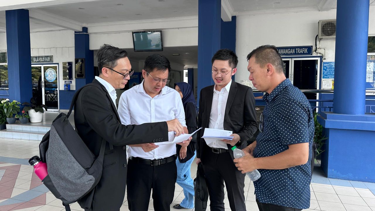 邹宇晖（左2）及郑益清（右）下午抵达劳勿警察总部，与律师讨论之前所获得的庭令。