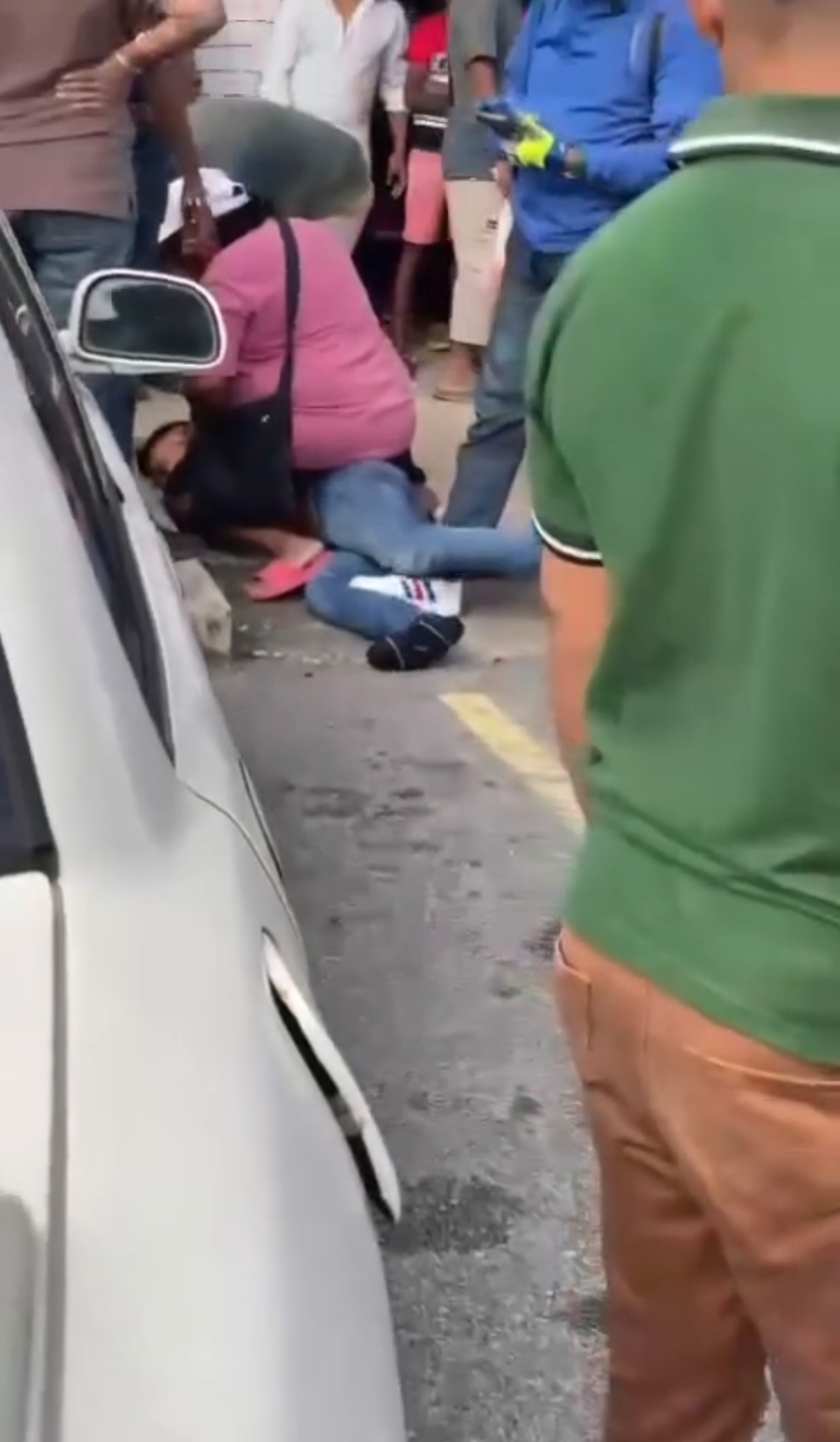 掠夺匪被当地民众制服，被压在路上无法动弹。