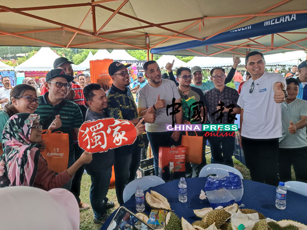 参与吃榴梿比赛的甲州媒体成员与莫哈末阿克马（右起）、刘志俍及诺希尔米（前排右四）合影留念。