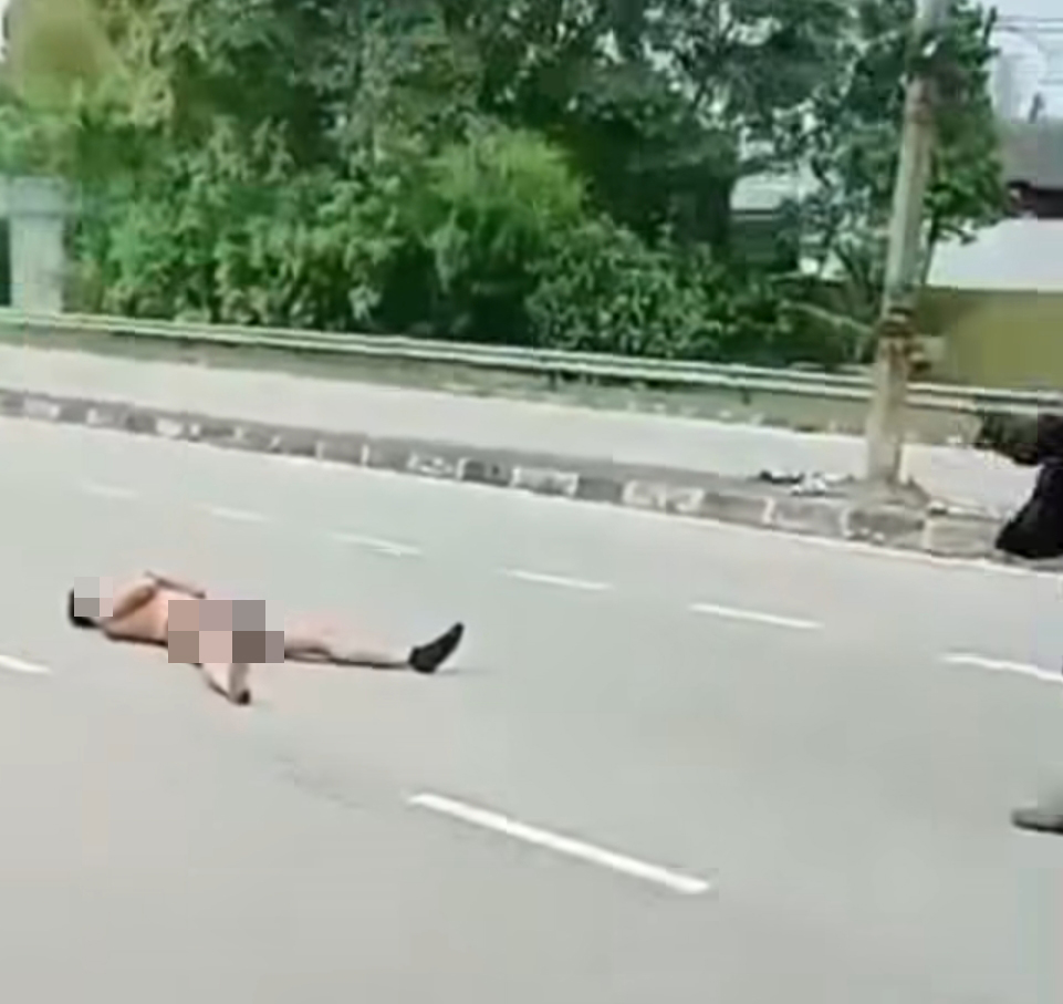 疯汉横躺在大马路上。