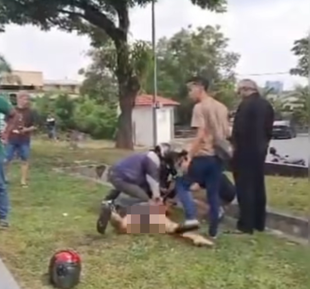 民众合力将疯汉的四肢捆绑。