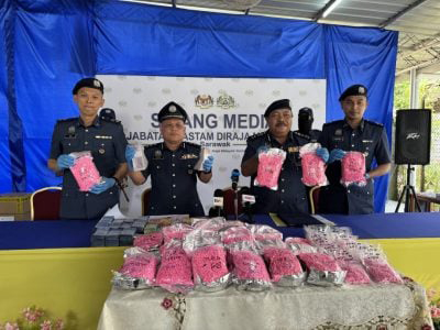 诺里占(右2)在官员的陪同下展示所起获的毒品。