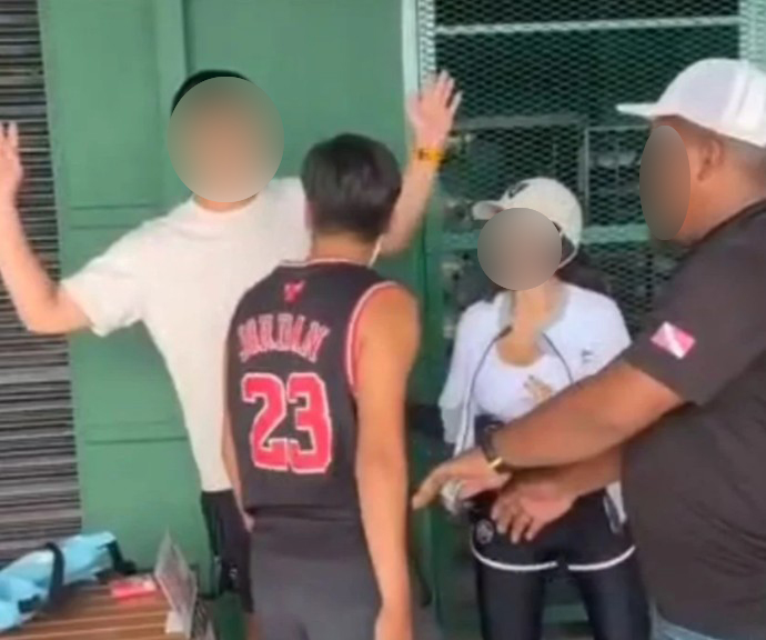 嫌犯(背对镜头者)与两名男女游客起争执后,怒掴两人。