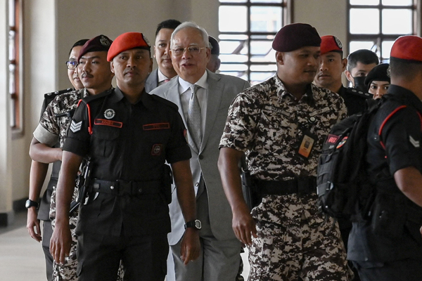 纳吉(左2)在狱卒的带领下,抵达法庭。