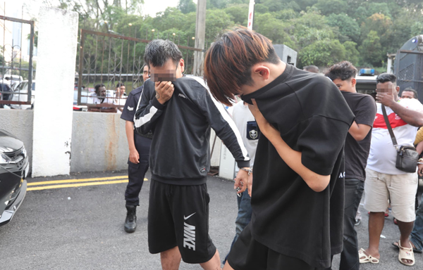 19岁被告黎明翰(左2)被警方带到新山法庭面控。