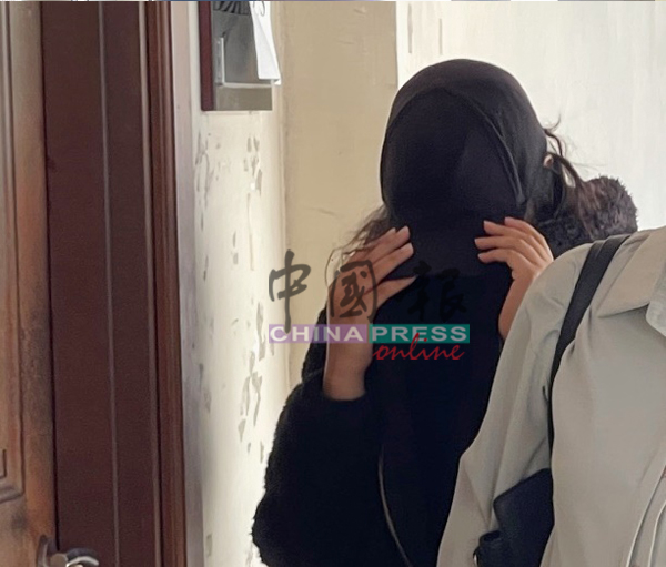 23岁女被告戴上鸭舌帽、口罩及外套,低头步行上庭。