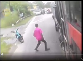 粉衣男子冲向正在驾驶中的罗厘，并趁机把脚伸进车底。