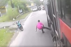 粉衣男子冲向正在驾驶中的罗厘，并趁机把脚伸进车底。