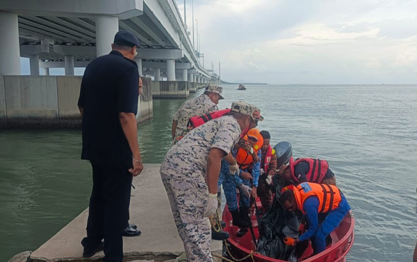 搜救人员将死者遗体打捞上搜救快艇，再送往水警基地码头上岸。