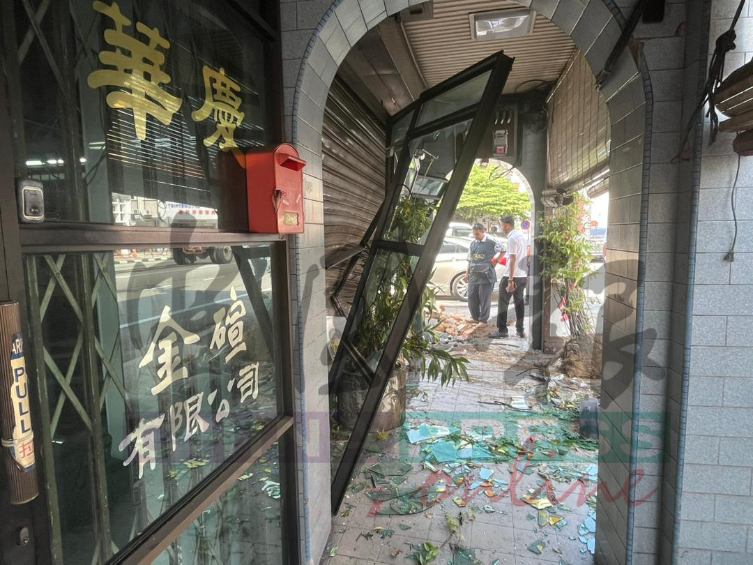 金店的右边店门遭受车辆撞击，左边店门则不受影响。