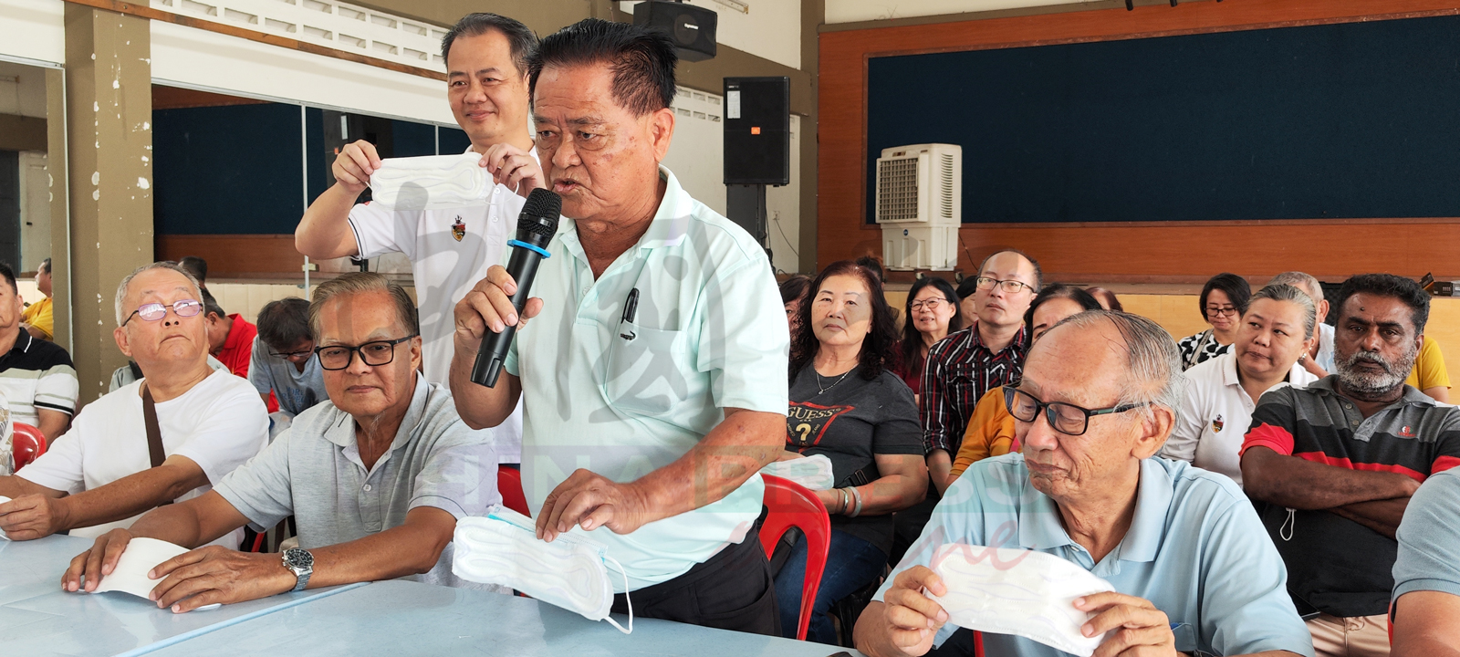 李光兴（前右2）手拿着特别改制的卫生棉口罩。