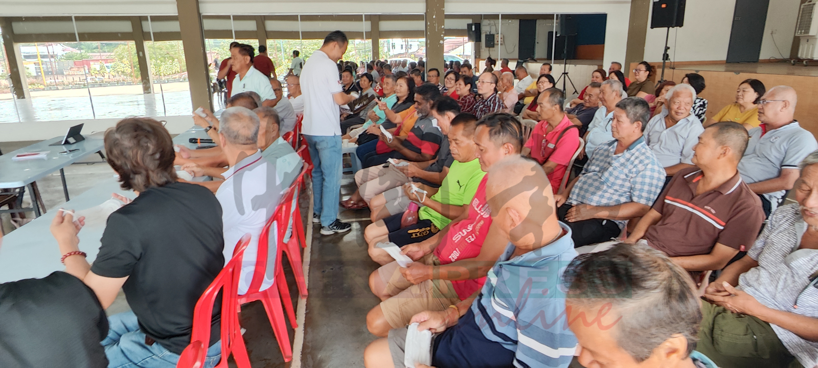 行动党森州元老俱乐部执行秘书林佑星在派发卫生棉口罩予党员。