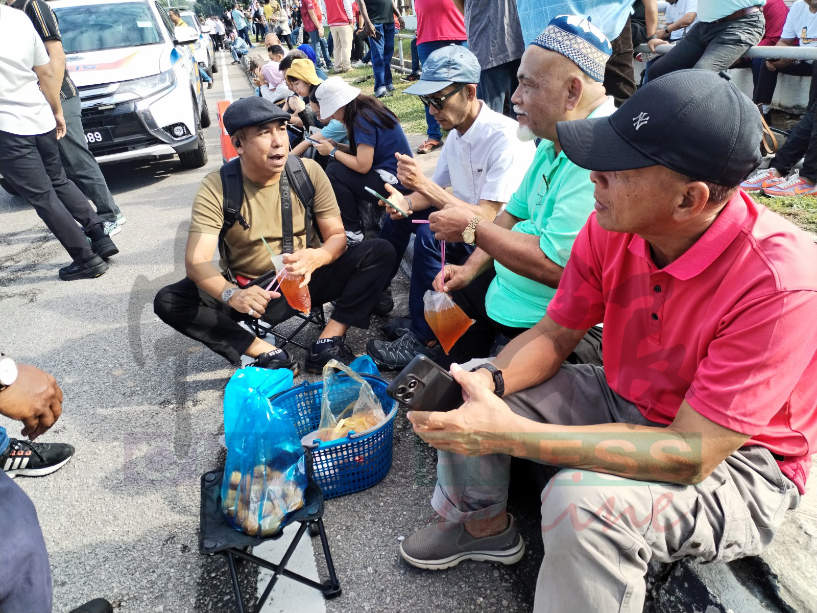 支持者坐在路旁，边吃喝边高谈阔论。