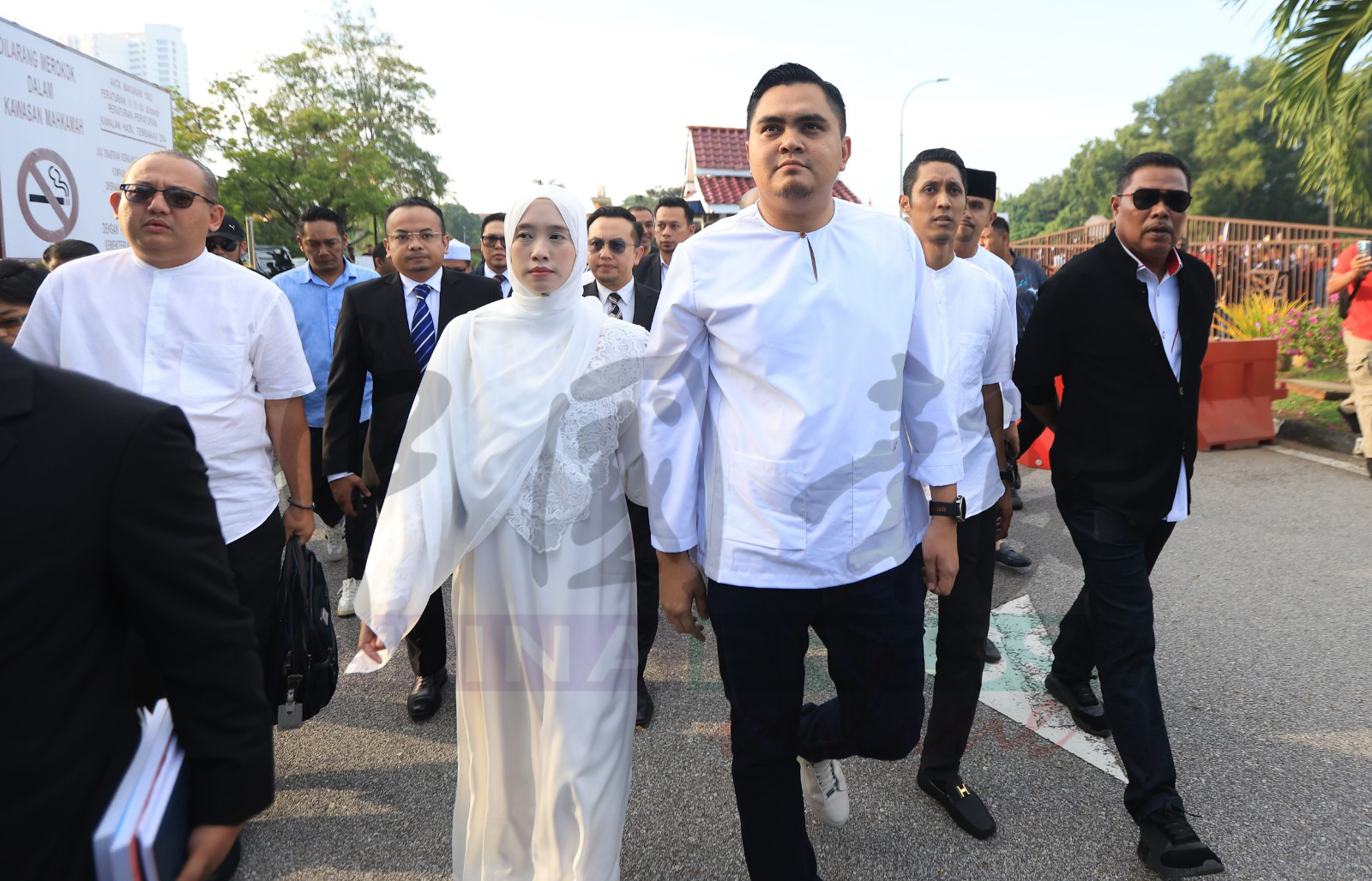 阿克马（前右）在妻子陪同下，抵达法庭。