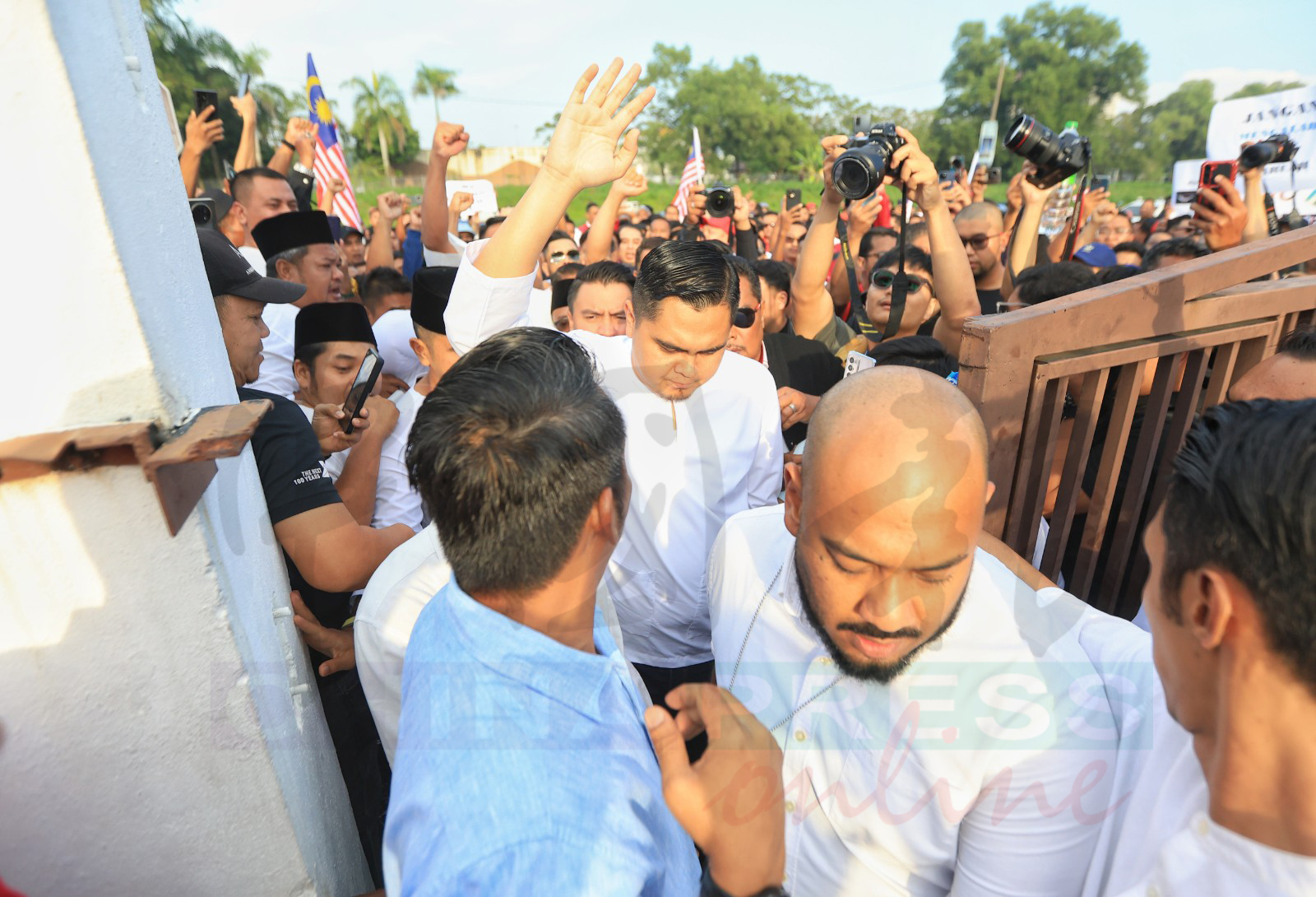 阿克马在支持者“拥护”下,步入法庭范围。