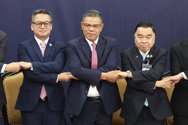 Malaysian Home Minister Saifuddin Nasution Ismail, sixth left, Thai and Cambodian delegates led by Thai Deputy Defense Minister Natthaphon Narkphanit, seventh left, and Cambodian Defense Minister General Tea Seiha, fifth left, pose for a group photo ahead of the Extraordinary General Border Committee (GBC) to discuss their border dispute between Cambodia and Thailand in Kuala Lumpur, Malaysia, Thursday, Aug. 7, 2025. (Hasnoor Hussain/Pool Photo via AP)