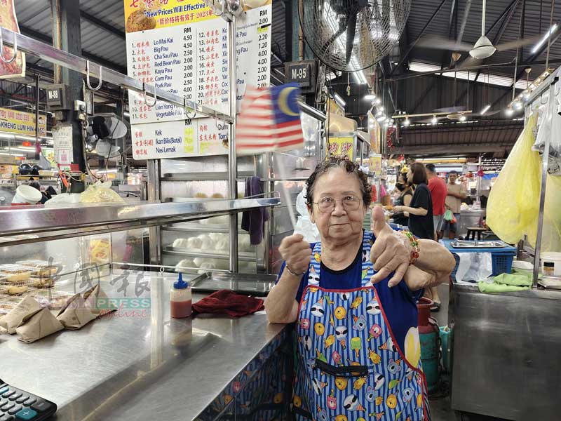 林贤英挥舞国旗，竖起拇指赞扬辉煌条纹很漂亮。
