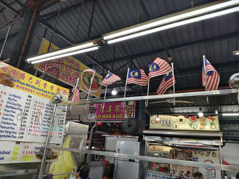 七条路巴刹熟食中心，糕点小贩林贤英的摊位从开业至今，长年插着7面小国旗营业。
