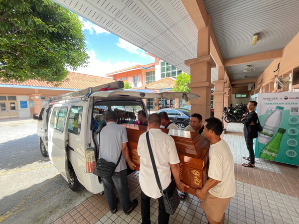 殡葬业工人合力将死者灵柩抬上灵车，准备送往灵堂治丧。