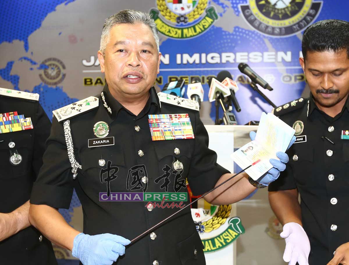 扎卡利亚向媒体解释集团伪造护照的手法。