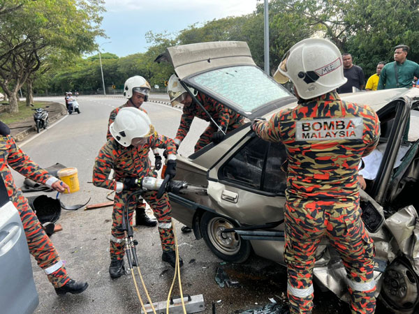 消拯人员撬开撞扁的门，以进行抢救工作。