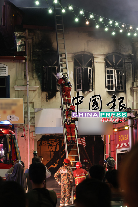 消拯员用楼梯爬往二楼扑灭火苗。