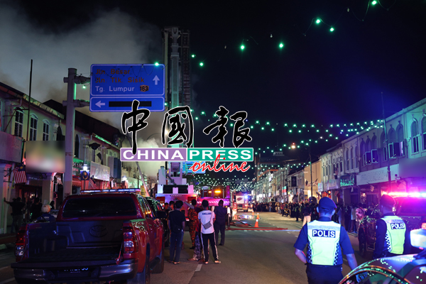 周二晚关丹马哥打路老店发生火灾，民众到火灾现场围观，警察到场维持秩序。