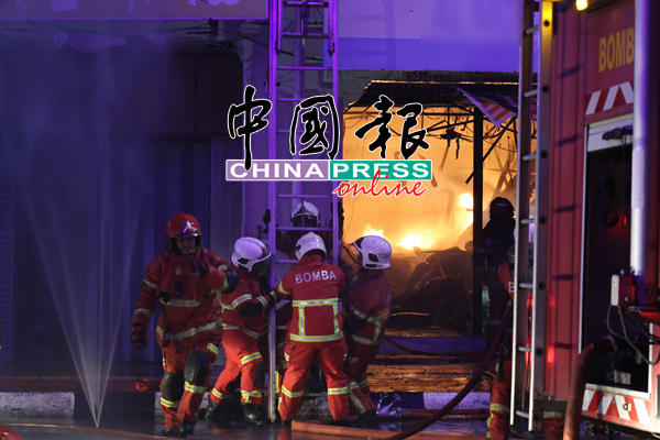 在火势不断蔓延情况下，消拯员准备爬梯灭火。