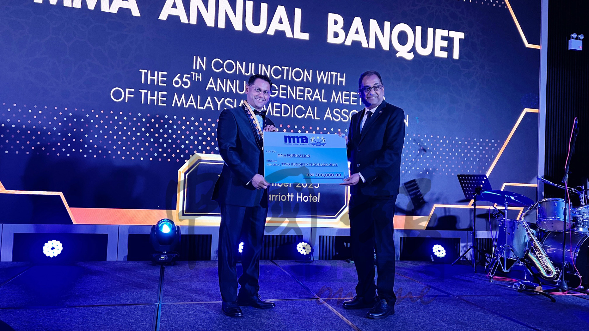 阿拉苏（左）移交模拟支票给MMA基金会，由再也古马接领。