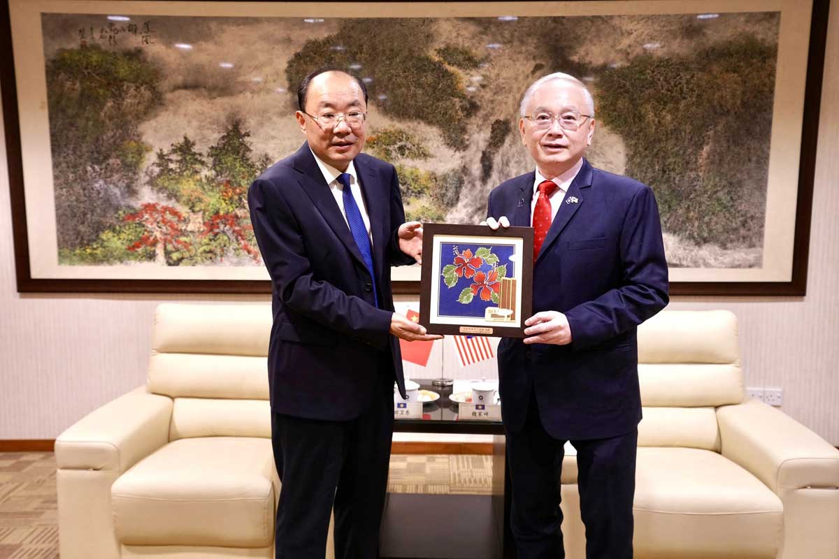 魏家祥（右）赠送田卫东一副大红花绘画。