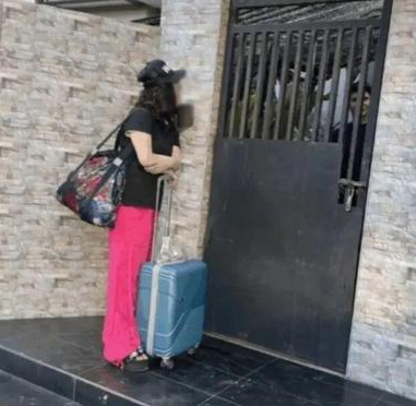 大妈带行李到塔尔家门口。