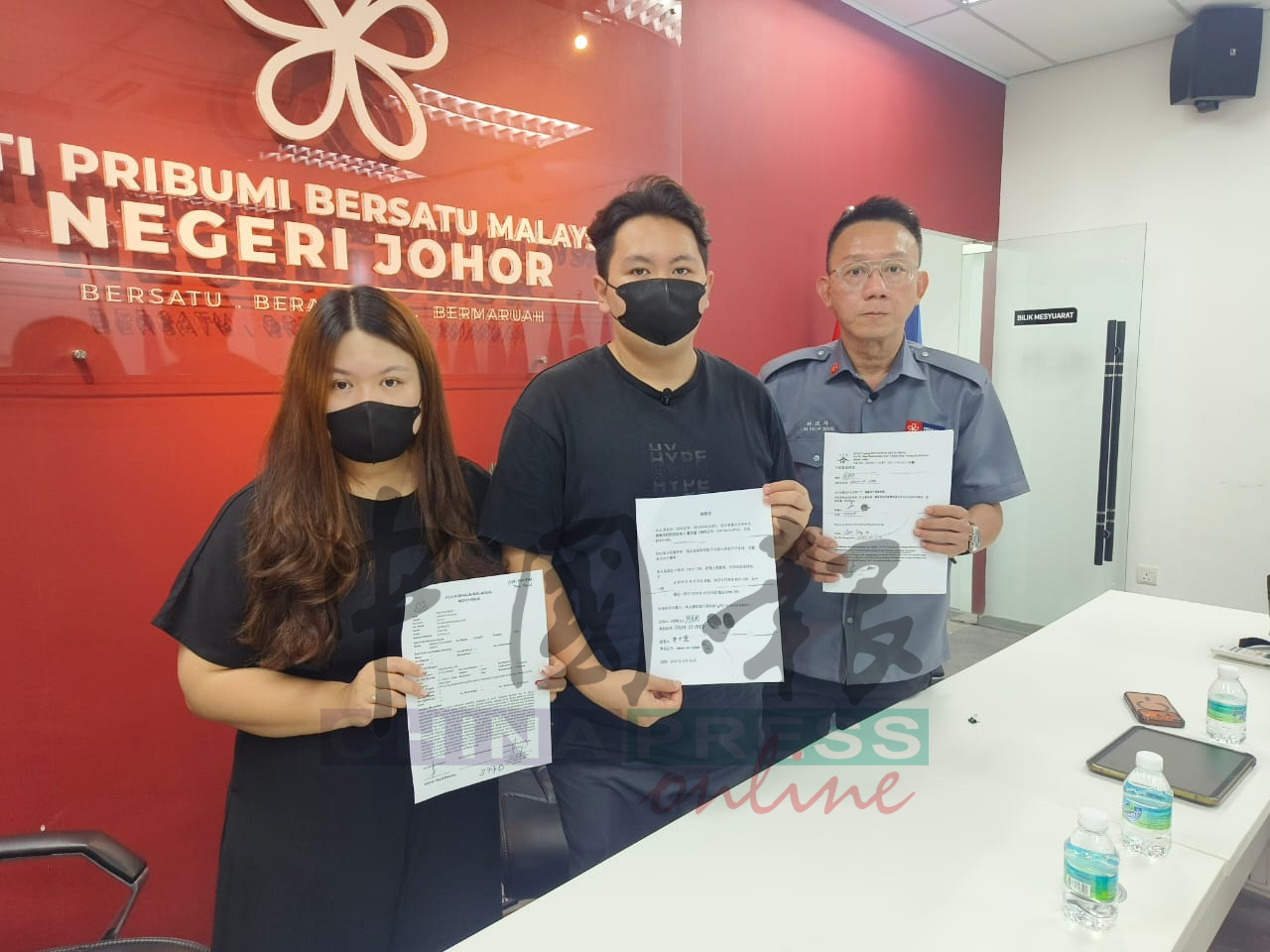 周姓青年(中)在姐姐(左起)和林道祥陪同下,展示报案信和被迫签下的赔偿信。