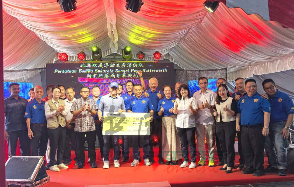 沈志强(左5起)在众人陪同下,移交模型支票给双溪浮油义消队主席陈国强。