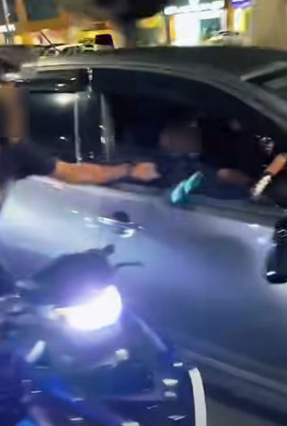 摩哆骑士踢踹车门，还做势向轿车司机挥拳。