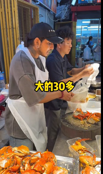 印裔小贩（左）以流利和风趣的中文交流，让中国游客留下深刻的印象。