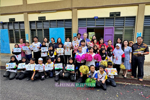 陈堂杰(后排左11)重返母校,受到师生举牌热烈欢迎。