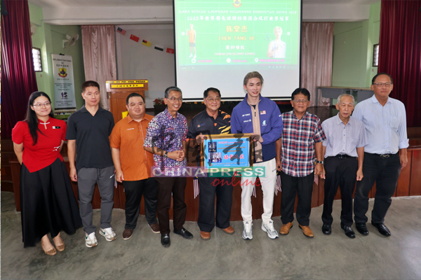 林亚烈(左五起)代表学校赠送牌匾予陈堂杰,左起为郑靖颖、陈宗银、郑振胜、赛夫巴哈里、卡玛、曾汉文及陈长兴。