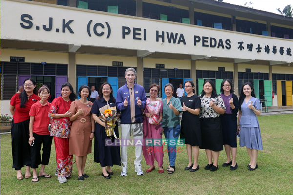 陈堂杰(左6)与师长们在校门前合影留念,见证他重返母校这一难忘时刻。