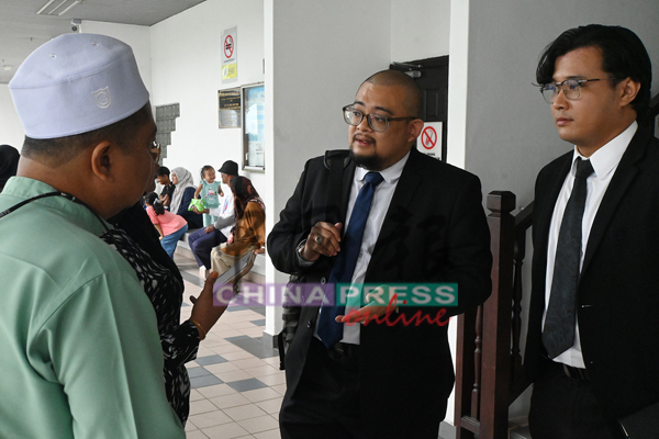 记者向阿末慕查法(右2)了解案情。