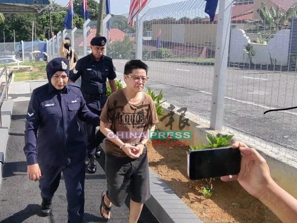 女大耳窿跑腿(中)身穿中性打扮,神情淡定步出居銮地庭,没有闪避媒体镜头。