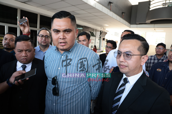 阿克马（中）在庭外召开记者会，辩护律师陪同在侧。