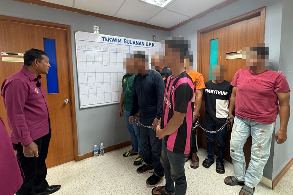 再努丁（左）盘问吸毒者。

