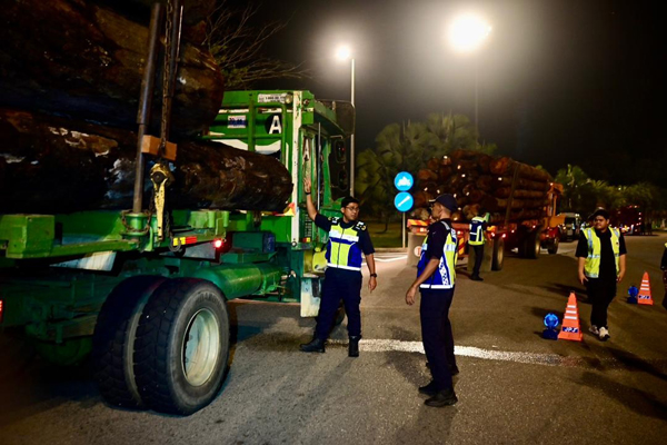 莫哈末占里（左）在取缔现场，监督下属执勤。