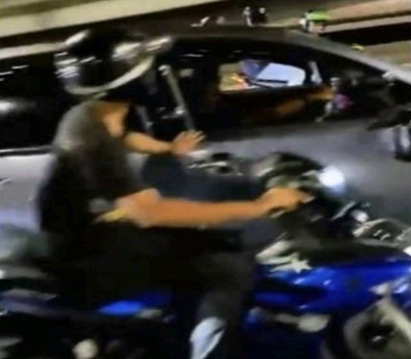 嫌犯边骑摩哆边威胁轿车司机。