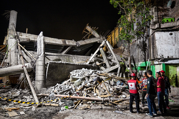 Rescue personnel inspect the site after a building collapsed at an Islamic boarding school in Sidoarjo, East Java province on September 29, 2025, injuring a number of students and trapping several others under the rubble. (Photo by Juni KRISWANTO / AFP)