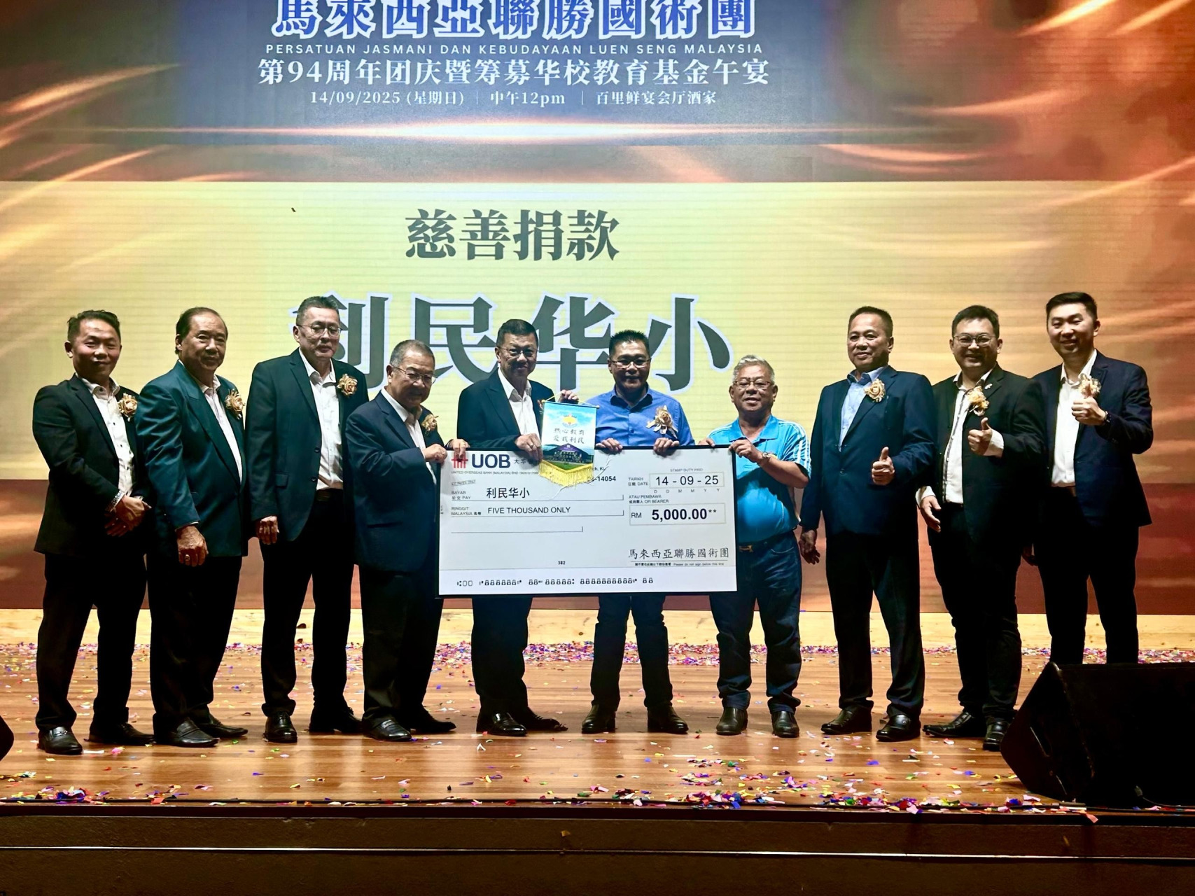 梁亚财（左4）颁发模拟支票给姚亚坤（右4），陈坤德（左5起）和蔡振文从旁见证；左起为潘志兴、黄成华、苏针林、罗宗文、李伟铭和陈杰胜。